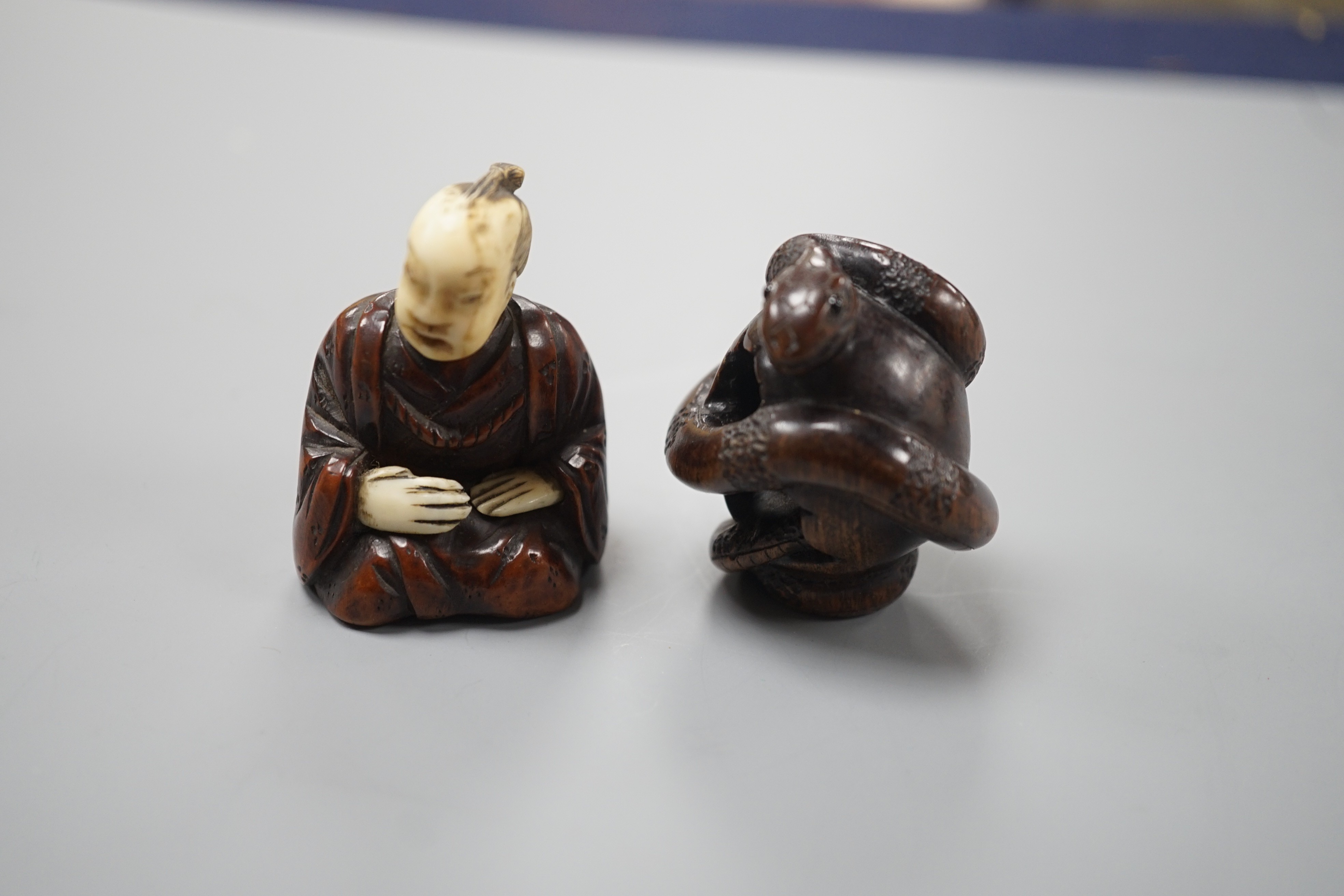 A Continental wood ‘chick and egg’ brooch ivory, 5.3cm, a Japanese ivory and wood figure and a wood netsuke of snakes (3)
